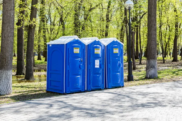 Baños públicos móviles en el parque de la ciudad en verano día soleado — Foto de Stock