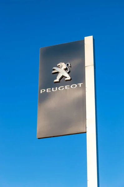 Sinal oficial de concessionária de Peugeot contra o backgro céu azul — Fotografia de Stock