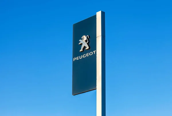 Znak oficjalnego dealera Peugeot przeciw błękitne niebo backgro — Zdjęcie stockowe
