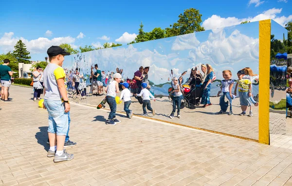 Persone vicino al gigantesco specchio in acciaio inox al parco della città in — Foto Stock