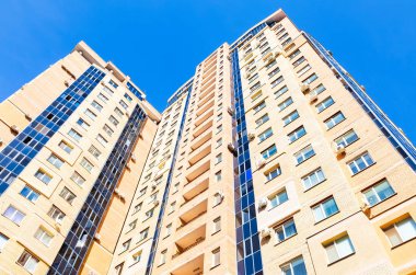 Mavi gökyüzü arka plan karşı yeni uzun boylu apartman