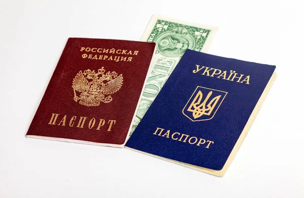 Ukrainian and Russian passports with one american dollar on the — Stock Photo, Image