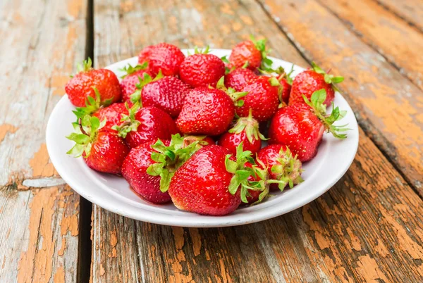 Fresh red strawberries in a white bowl standing on the rustic wo — Stock Photo, Image