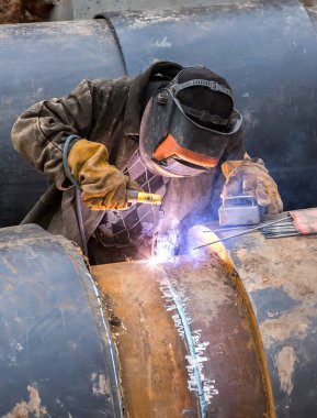 İşçi ile koruyucu maske kıvılcım ve duman ile metal kaynak