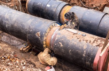 İşçiler, kaynakçılar elektrik büyük demir boru kaynak tarafından yapılan