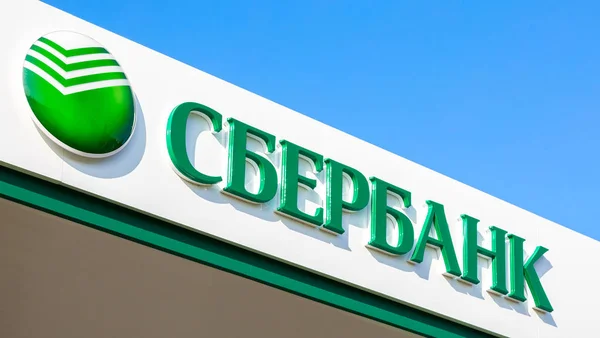 Logga med logotypen kontoret av den ryska Sberbank mot bl — Stockfoto