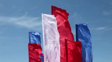 Rüzgara karşı mavi gökyüzü içinde çırpınan bayrakları