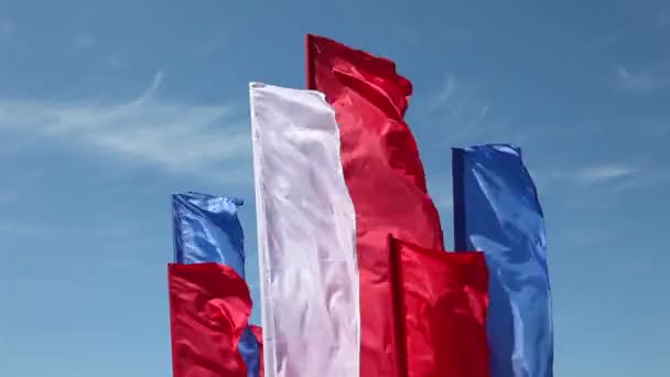 Banderas ondeando en el viento contra el cielo azul — Vídeos de Stock