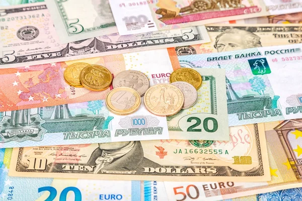 Different coins lying over different currency banknotes euro, do — Stock Photo, Image