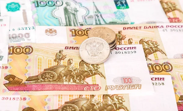 Rublos rusos monedas que yacen sobre diferentes billetes de moneda clo —  Fotos de Stock