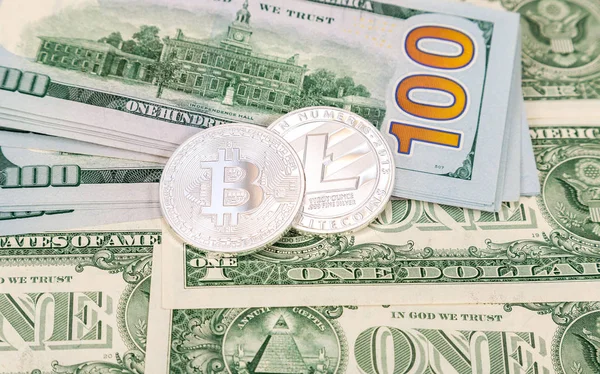 Монеты криптовалюты лежат над банкнотами в долларах США. Бузин — стоковое фото
