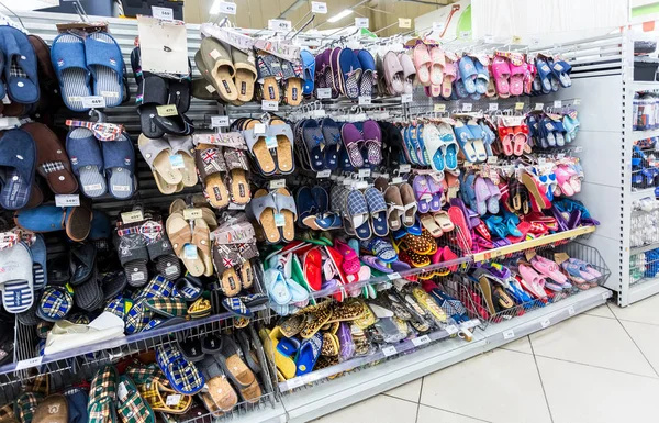 Verschillende slippers klaar voor verkoop op showcase in nieuwe hypermarkt — Stockfoto