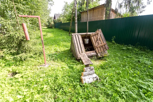 Старый деревенский деревянный колодец для воды за городом в летний день — стоковое фото