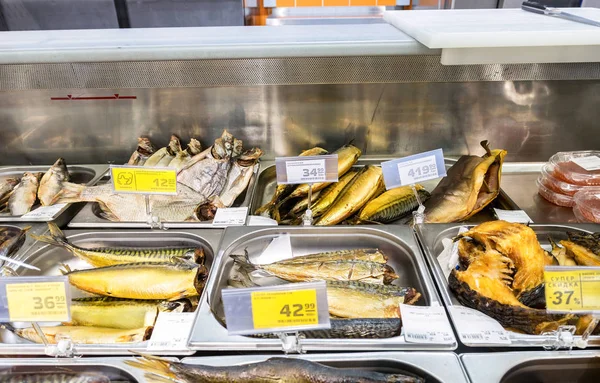 Escaparate con sabroso pescado ahumado y seco en hipermercado — Foto de Stock