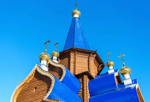 Igreja ortodoxa de madeira tradicional com cúpulas contra o azul s — Fotografia de Stock