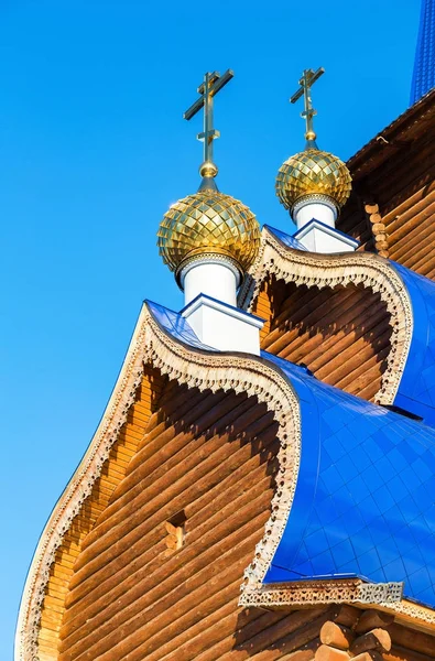 Золоті куполи з хрестами на дерев'яній православній церкві проти — стокове фото