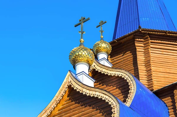 Cúpulas douradas com cruzes em igreja ortodoxa de madeira contra o — Fotografia de Stock