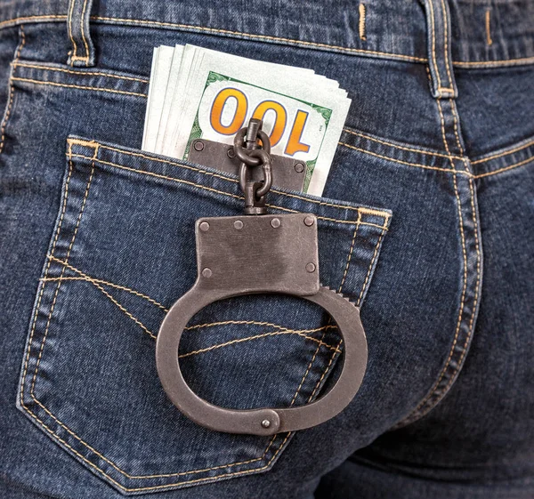 Police metal handcuffs and american currency in back jeans pocke — Stock Photo, Image