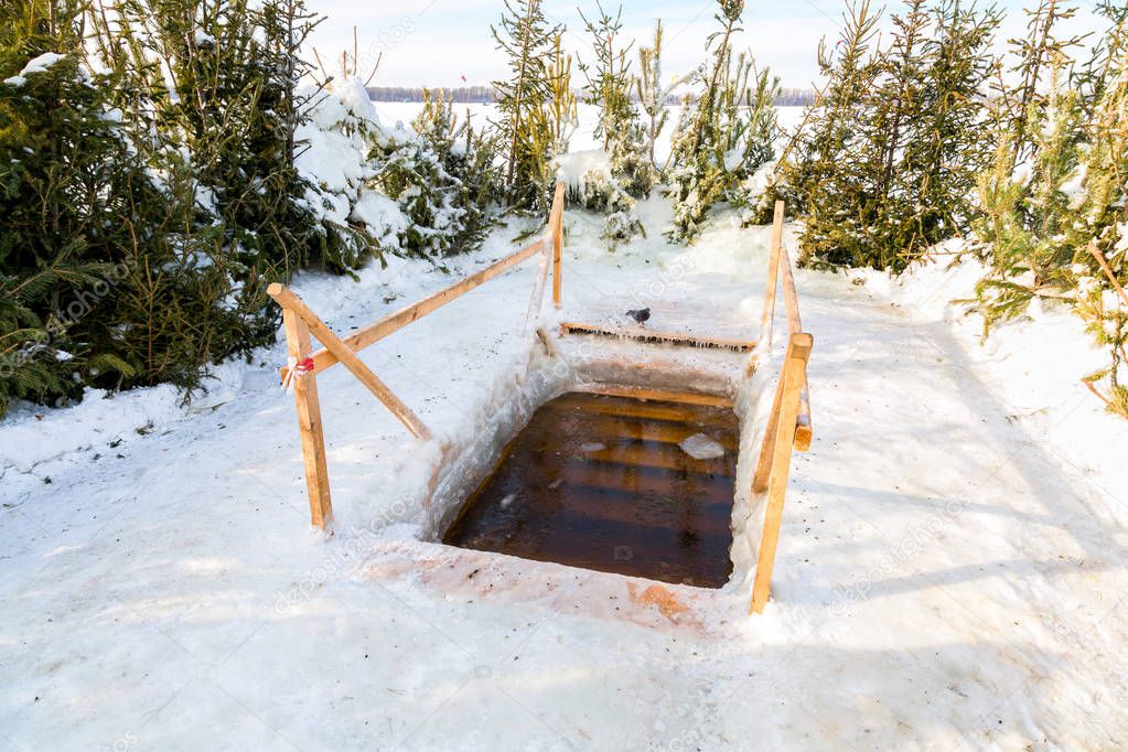 Ice hole for traditional winter swimming at the river in Russia