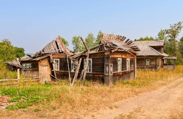 Viejas casas rotas de madera en pueblo ruso abandonado — Foto de Stock