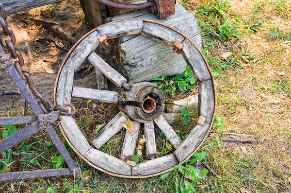 Старое деревянное сломанное колесо в заброшенной деревне в летний день — стоковое фото
