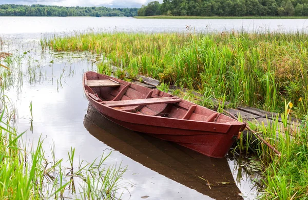 Old fishing wooden boat at the lake in sunny summer day — Stock Photo, Image