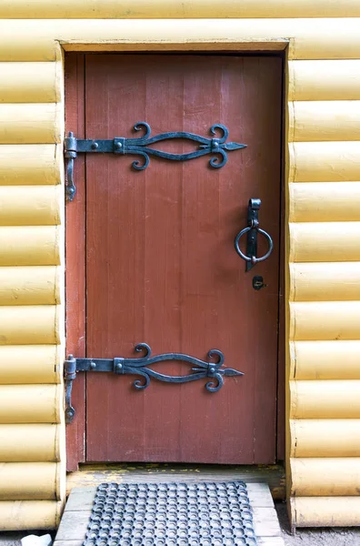 Традиционная русская деревянная дверь с коваными массивными металлическими петлями — стоковое фото