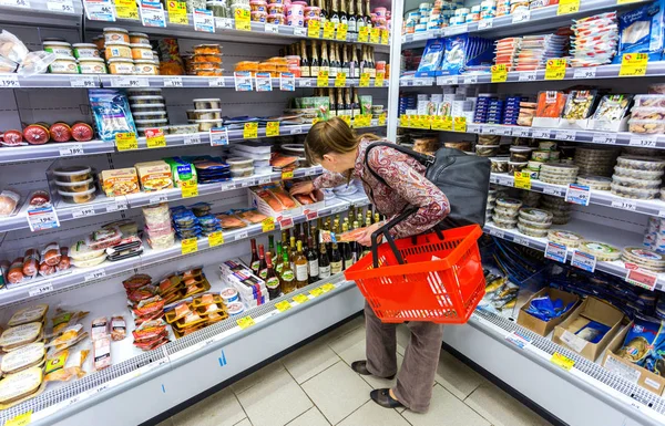 Mujer joven eligiendo salmón pescado en las compras en cadena supermarke — Foto de Stock