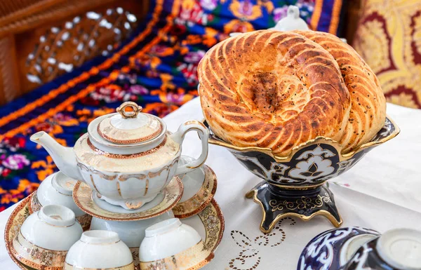 Pão chato uzbeque fresco com sementes de gergelim na mesa de férias — Fotografia de Stock