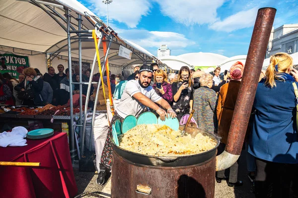 Koken smakelijke traditionele oosterse pilaf in een grote ketel — Stockfoto