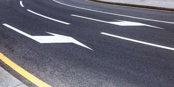 Traffic sign white arrows on asphalt road
