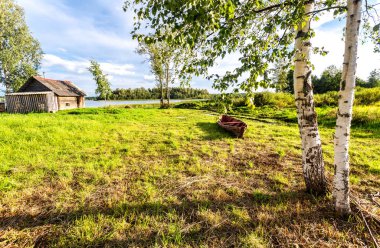 Huş ağacının yanındaki eski ahşap balıkçı teknesi.