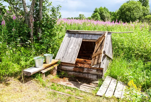 Houten waterput op het platteland — Stockfoto