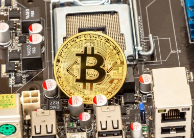 Samara, Russia - December 11, 2017: Golden bitcoin lying over electronic computer component. Business concept of digital cryptocurrency