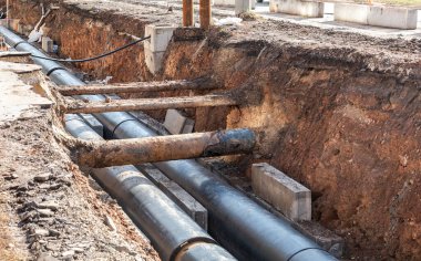 Isıtma borularının değiştirilmesi ve ısıtma sisteminin modernizasyonu. Eski paslı metal boruların onarımı. Kazılan açma derinliğinde büyük demir borular üzerinde inşaat işleri