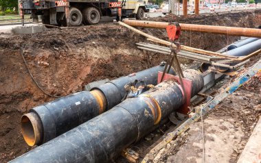Samara, Rusya - 1 Ekim 2017: Isıtma borularının değiştirilmesi ve ısıtma sisteminin modernizasyonu. Paslı metal boruların tamiri. İnşaat, kazılmış hendek derinliğindeki büyük demir borular üzerinde çalışıyor.