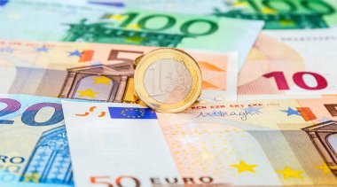 Farklı avro banknotlarından oluşan kağıt para arkaplanı ve bir avro para.