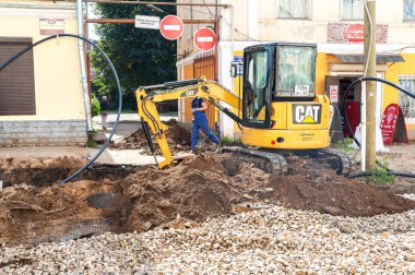 Borovichi, Rusya - 22 Temmuz 2019: Yaz günü şehir caddesinde yeni yol inşaatında çalışan küçük bir kepçe