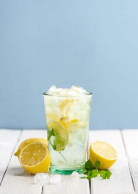 Soğuk limonata ve taze limon mavi üzerinde beyaz bir ahşap tablo