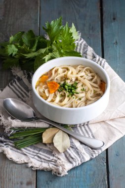 Eski bir ahşap sekmesinde ev yapımı erişte ile ev yapımı tavuk çorbası