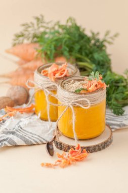 Açık şeftali arka planı üzerinde havuç pudingle iki kavanoz