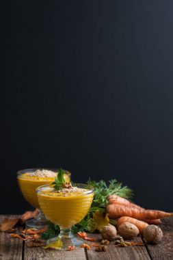 Havuç puding ezilmiş fındık ile siyah bir arka plan üzerinde servis edilir