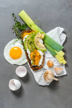 Avokado, tatlı biber salçası ve üzerinde bir gr kızarmış yumurta sandviç