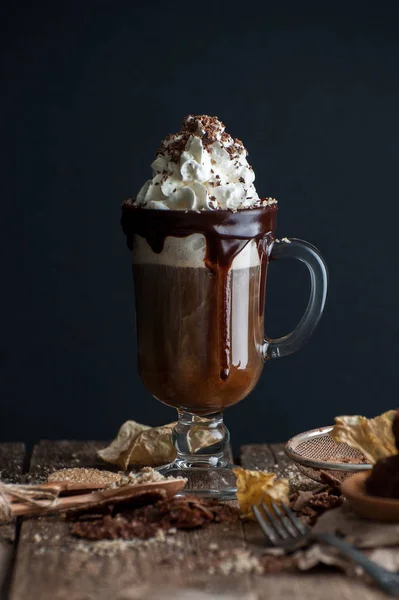 Kopi dengan krim kocok dan coklat di meja kayu tua — Stok Foto