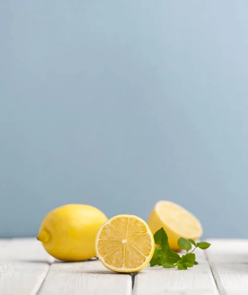 Olgun limon ve nane yaprakları mavi ba bir beyaz tahta masada