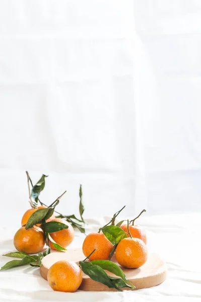 Zralé mandarinky s větvičkami na kulaté desce. Fotografie s negativní Stock Obrázky