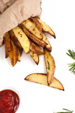Biberiye ve beyaz bir arka ketçap ile pişmiş patates dilimleri