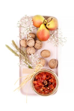 Bir hafif pembe tepsi üzerinde Armut Reçeli, armut ve ceviz servis edilir bir