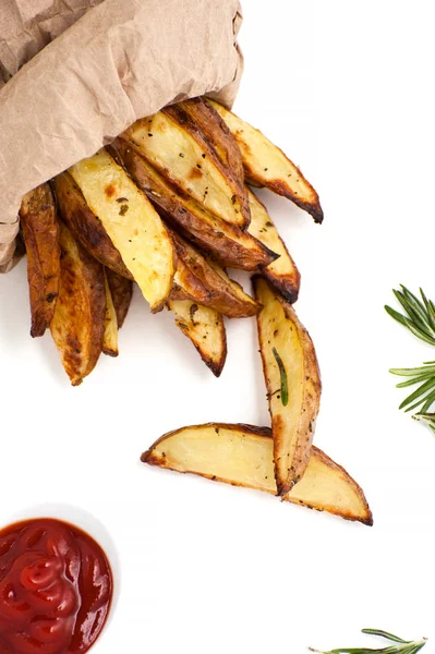 Plakjes gebakken aardappel met rozemarijn en ketchup op een witte rug — Stockfoto