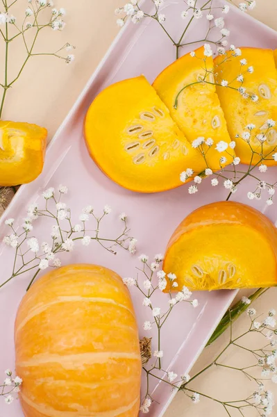 Las rodajas de la calabaza fresca joven en un plato de color rosa claro en una naranja — Foto de Stock